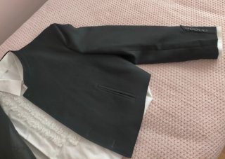 Chaqueta corta traje y camisa blanca con encajes.
