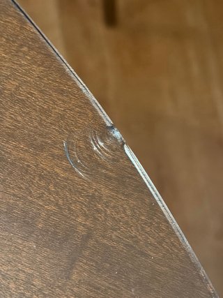 Mesa redonda de comedor de madera y cristal.