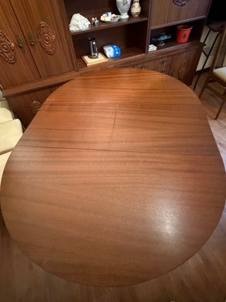 Mesa redonda de comedor de madera y cristal.
