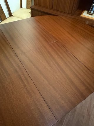 Mesa redonda de comedor de madera y cristal.