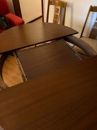 Mesa redonda de comedor de madera y cristal.