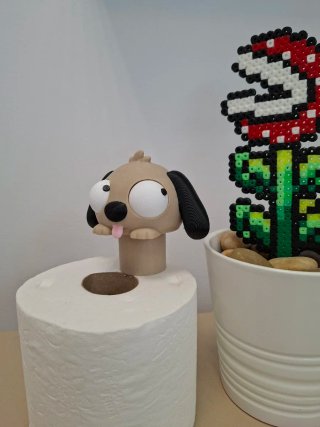 Perrito asomando sobre rollo de papel