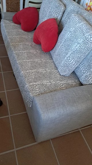 Sofá gris con cojines rojos