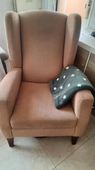 Sillón orejero individual beige.
