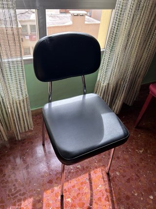 Silla de piel negra con estructura metálica