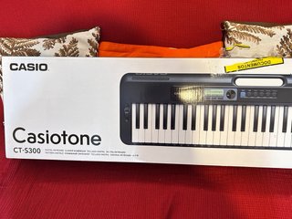 Casio CT-S300 con pedestal y partitura