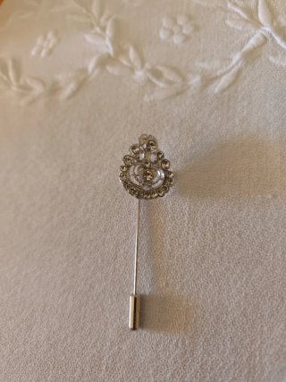 Broche plateado con pedrería