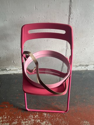 Silla rosa y espejo redondo