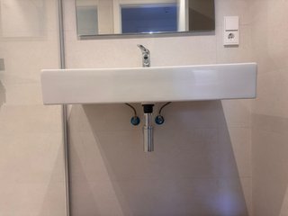 Lavabo de baño con grifería y espejo