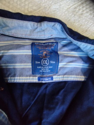 Camisa vaquera azul con ribete naranja.