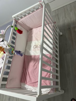 Cuna de bebé con colcha rosa