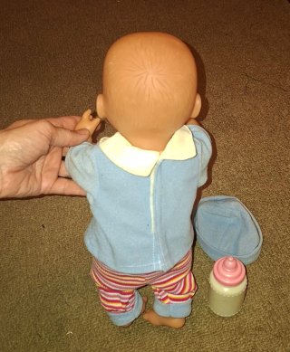 Muñeco bebé con gorrito biberón y orinal