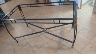 Mesa de hierro forjado con detalles dorados,