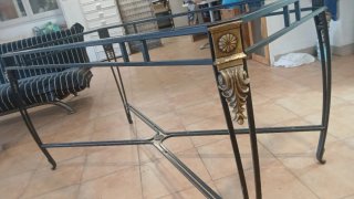 Mesa de hierro forjado con detalles dorados,