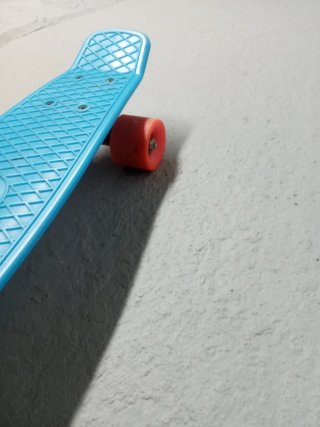 Patinete azul con ruedas naranjas