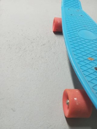Patinete azul con ruedas naranjas