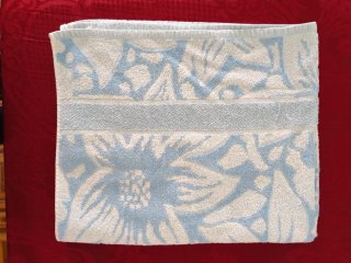 Toalha de banho azul e branca com padrão floral