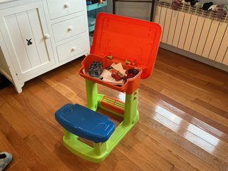 Escritorio infantil con asiento y cajón.