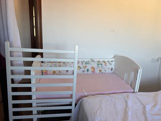 Cuna blanca con protector estampado y colchon .