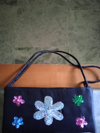 Bolso de mano negro con flores brillantes