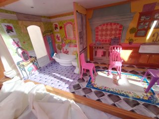 Casa de muñecas rosa con muebles