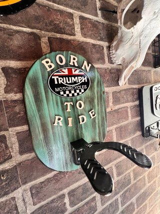Triumph cartel moto colgador