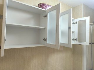 Mueble de baño blanco con puertas de cristal