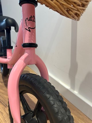 Bicicleta sin pedales rosa con cesta