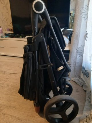 Carrito de bebé negro con barra marrón