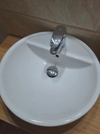 Mueble de baño con lavabo, grifo, espejo y focos.