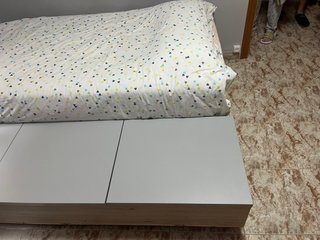 Cama con base de madera y cajones grises
