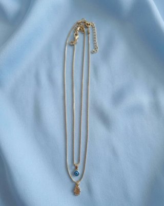 Dos collares dorados con ojo turco y mano
