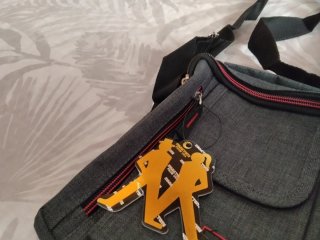 Bolso bandolera gris con detalles naranjas