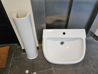 Pileta de cerámica con pedestal, sin grifería.