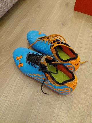 Botas de fútbol Under Armour azules y naranjas