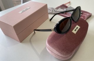 Gafas de sol Miu Miu negras y doradas