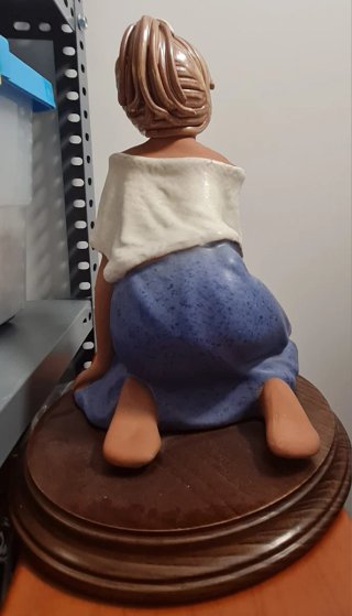 Niña de cerámica sentada con flores