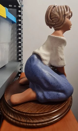 Niña de cerámica sentada con flores