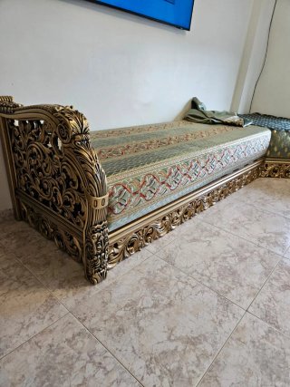 Sofá de madera tallada y cojines