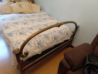 Cama antigua dorada con cabecero ornamentado