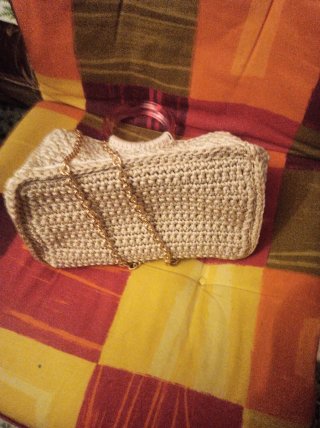 Bolso tejido beige con cadena dorada