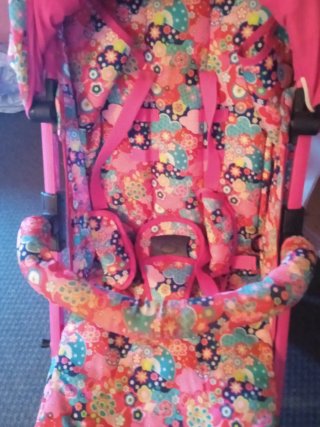 Cochecito de bebé rosa con bolso y cesta