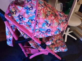 Cochecito de bebé rosa con bolso y cesta