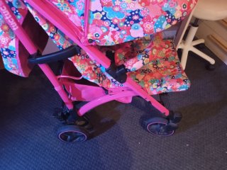 Cochecito de bebé rosa con bolso y cesta