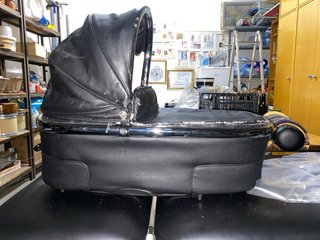 Carro de bebé negro de cuero.