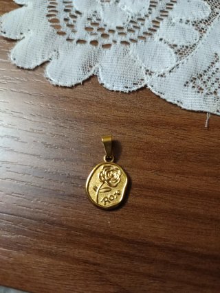 Medalla de acero dorado con rosa.