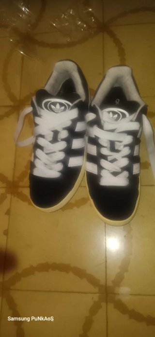 Zapatillas Adidas Negras y Blancas y Vans moradas.