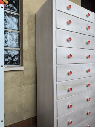 Cómoda alta blanca con tiradores blancos y rojos