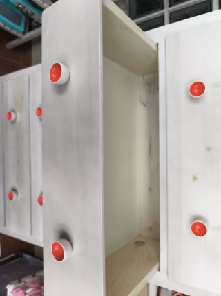 Cómoda alta blanca con tiradores blancos y rojos