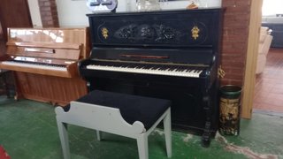Piano vertical negro con banqueta
